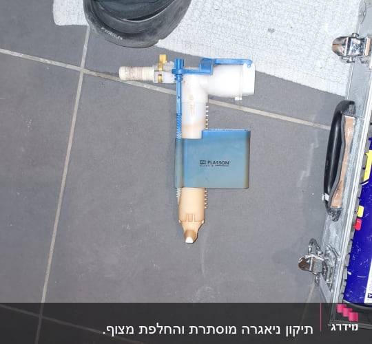 חלקי אינסטלציה וכלים על רצפה אפורה